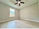 Bright bedroom featuring hardwood floors, a ceiling fan, and natural light from the large window at 8289 Se 159Th Ln, Summerfield, FL 34491
