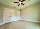 Bright bedroom featuring hardwood floors, a ceiling fan, and double door closet at 8289 Se 159Th Ln, Summerfield, FL 34491