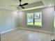 Bright bedroom features wood floors, a modern ceiling fan, and a large window with a view of the outdoors at 8289 Se 159Th Ln, Summerfield, FL 34491