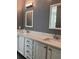 Bathroom features a double vanity with white cabinets and a speckled granite countertop at 8298 Sw 79Th Cir, Ocala, FL 34476