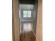 Bedroom view from the hallway showcasing wood floors and large window at 8298 Sw 79Th Cir, Ocala, FL 34476