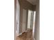 Hallway featuring wood floors, white trim, and multiple doors leading to different rooms at 8298 Sw 79Th Cir, Ocala, FL 34476