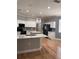 Open kitchen with white cabinets, hardwood floors, an island, and stainless steel appliances at 8298 Sw 79Th Cir, Ocala, FL 34476