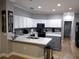 Well-lit kitchen with white cabinets, gray countertops, modern appliances, and updated backsplash at 8298 Sw 79Th Cir, Ocala, FL 34476