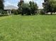 Picture of a lush green backyard with mature trees and a distant white trellis at 8781 Sw 82Nd Court Rd, Ocala, FL 34481