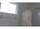 Bathroom featuring a window, shower curtain, and grab bar, promoting safety and comfort at 8781 Sw 82Nd Court Rd, Ocala, FL 34481