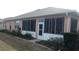 Peach home exterior featuring a screened-in porch with a white door and surrounding garden at 8781 Sw 82Nd Court Rd, Ocala, FL 34481