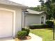 A beautiful home exterior highlighting the attached garage, and trimmed bushes at 9328 Sw 192Nd Court Rd, Dunnellon, FL 34432