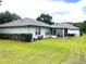 Exterior view of the house showing the backyard, screened-in porch, and well-manicured landscaping at 9328 Sw 192Nd Court Rd, Dunnellon, FL 34432