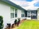 Exterior view of the house showing the windows, screened-in porch, and well-manicured landscaping at 9328 Sw 192Nd Court Rd, Dunnellon, FL 34432