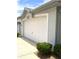 Attached two car garage featuring a white garage door, beautiful plants, and well maintained exterior at 9328 Sw 192Nd Court Rd, Dunnellon, FL 34432