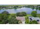 Aerial view of a lakeside home with a pool and lush landscaping, nestled in a peaceful neighborhood at 95 Hickory Loop, Ocala, FL 34472