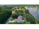 Scenic aerial view of a home with solar panels and lake access surrounded by trees at 95 Hickory Loop, Ocala, FL 34472