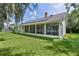 The home features a large screened lanai, solar panels, and a lush green lawn extending to the water's edge at 95 Hickory Loop, Ocala, FL 34472
