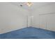 Empty bedroom featuring bright blue carpet, white walls, and a ceiling fan at 95 Hickory Loop, Ocala, FL 34472