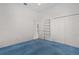 Neutral bedroom features a built-in bookshelf, closet, and plush blue carpet at 95 Hickory Loop, Ocala, FL 34472