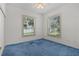 Vacant bedroom with blue carpeting, white walls and two bright, window views at 95 Hickory Loop, Ocala, FL 34472