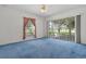 Bedroom with large windows showcasing a peaceful lake view and plush blue carpet at 95 Hickory Loop, Ocala, FL 34472