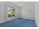 Bright bedroom with blue carpeting, white walls, and a large window at 95 Hickory Loop, Ocala, FL 34472