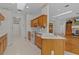 A kitchen with wooden cabinets, white appliances, and a view of an open-concept living space at 95 Hickory Loop, Ocala, FL 34472