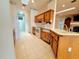 Bright kitchen featuring skylight, tile floor, wood cabinets, and view to fireplace at 95 Hickory Loop, Ocala, FL 34472