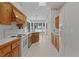 Cozy kitchen with views of the lake and featuring wooden cabinets and modern white appliances at 95 Hickory Loop, Ocala, FL 34472