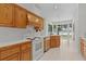 Inviting kitchen boasts wood cabinets, white appliances and overlooks a serene water view at 95 Hickory Loop, Ocala, FL 34472