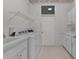 Bright laundry room with white appliances, tile flooring, and overhead storage at 95 Hickory Loop, Ocala, FL 34472