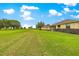 Spacious backyard with green grass, manicured bushes, and partial view of house at 9551 Sw 92Nd Ter, Ocala, FL 34481