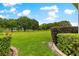 Lush backyard with manicured lawn, bordered by decorative bushes, leading to a grassy common at 9551 Sw 92Nd Ter, Ocala, FL 34481