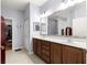 Bathroom has double sinks, a large mirror, and tiled floors at 9551 Sw 92Nd Ter, Ocala, FL 34481