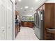 Kitchen featuring dark wood cabinets, stainless steel appliances, and tiled flooring at 9551 Sw 92Nd Ter, Ocala, FL 34481