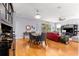 Open concept living area with hardwood floors, dining table, and a comfortable red sofa at 9551 Sw 92Nd Ter, Ocala, FL 34481