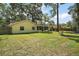 Spacious backyard with a fire pit and swing set surrounded by mature trees, ideal for outdoor enjoyment at 986 Se 57Th Ave, Ocala, FL 34480