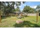 Outdoor oasis with a charming swing set, inviting fire pit, and lush green lawn at 986 Se 57Th Ave, Ocala, FL 34480