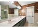 Spacious bathroom with dual sinks, a large mirror, patterned wallpaper, and tile flooring at 986 Se 57Th Ave, Ocala, FL 34480