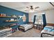 Charming bedroom featuring built-in shelving, a window, a ceiling fan, and two beds at 986 Se 57Th Ave, Ocala, FL 34480