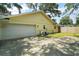 Side view of a one-story home featuring a two-car garage, concrete driveway, and fenced yard at 986 Se 57Th Ave, Ocala, FL 34480