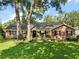 Charming brick and siding home with mature trees and a welcoming front porch with rocking chairs at 986 Se 57Th Ave, Ocala, FL 34480