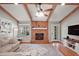Spacious living room with exposed beams, hardwood floors, brick fireplace and a large window at 986 Se 57Th Ave, Ocala, FL 34480