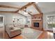 Bright and airy living room featuring wood beams, brick fireplace, hardwood floors, and neutral décor at 986 Se 57Th Ave, Ocala, FL 34480