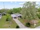 An aerial shot shows the single-story home's carport, screened porch, and large, tree-lined lot at 10012 Sw 88Th Ct, Ocala, FL 34481