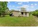 Exterior view of the home's backyard featuring a well-maintained lawn and mature landscaping at 10012 Sw 88Th Ct, Ocala, FL 34481