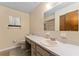 Bathroom featuring a long vanity with modern faucet, toilet, framed mirror, and shower/tub combo at 10012 Sw 88Th Ct, Ocala, FL 34481