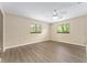 Spacious bedroom featuring plank flooring, neutral walls, a ceiling fan, and plenty of natural light from dual windows at 10012 Sw 88Th Ct, Ocala, FL 34481