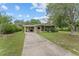 A well-maintained single-story home features a carport, screened porch, and long driveway at 10012 Sw 88Th Ct, Ocala, FL 34481
