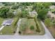 An aerial view showcases a neatly kept lawn, pruned shrubbery, and a charming single-story home at 10012 Sw 88Th Ct, Ocala, FL 34481