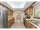 Well-lit kitchen featuring stainless steel refrigerator and appliances, complemented by wooden cabinetry at 10012 Sw 88Th Ct, Ocala, FL 34481