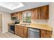 Kitchen with stainless steel dishwasher and sink, plus wooden cabinetry and countertops at 10012 Sw 88Th Ct, Ocala, FL 34481