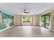 Large living room with a mural, ceiling fan and sliding door at 10012 Sw 88Th Ct, Ocala, FL 34481